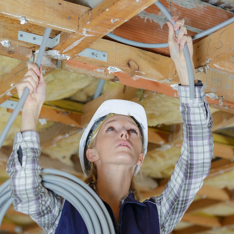 builder woman holding cables in site